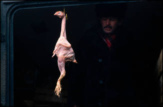 A vendor sells a plucked chicken at a street market, Moscow, Russia