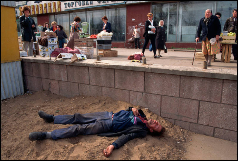 Drunk man lying in the dirt near a market, Kirov, Russia